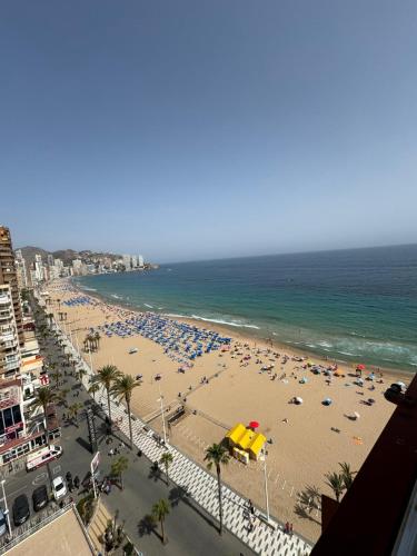 een strand met veel parasols en de oceaan bij Iberia Apartment in Benidorm