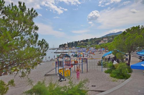 a group of people on a beach with a playground at Apartment Elza in Ičići