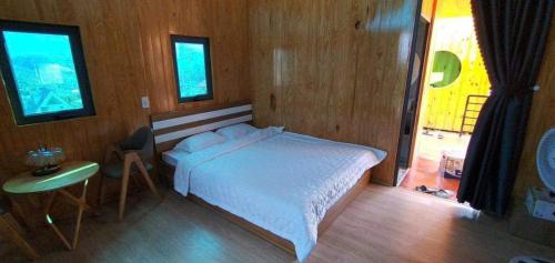 una camera da letto con un letto bianco e una finestra di Khu Nghỉ Dưỡng Lộc Nam Hill Bảo Lộc a Pro Lach (2)