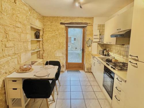 een keuken met een aanrecht en een tafel met stoelen bij La Casa de Pipo Au cœur de Sarlat in Sarlat-la-Canéda