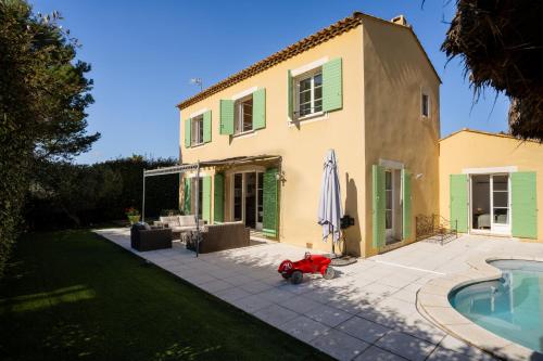 une maison avec un chien pondant à côté d'une piscine dans l'établissement Villa avec Piscine sur le Golf, à Béziers