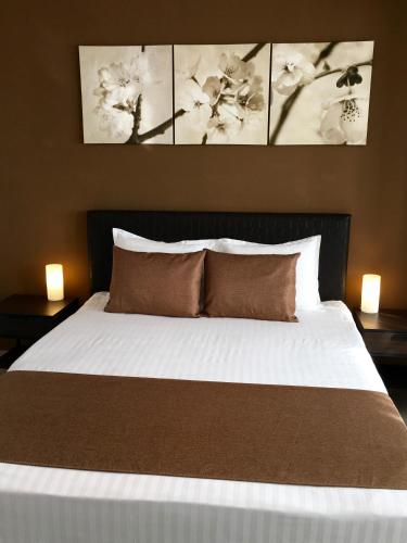 a bedroom with a white bed with two nightstands and two lamps at Elysium in Bucharest