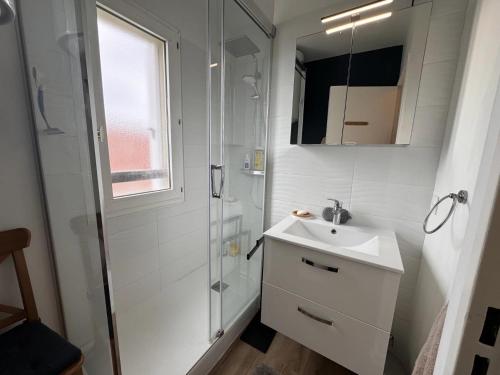 une salle de bain blanche avec un lavabo et une douche dans l'établissement Proche Mer - 2 pièces Balcon au SUD, à Cabourg