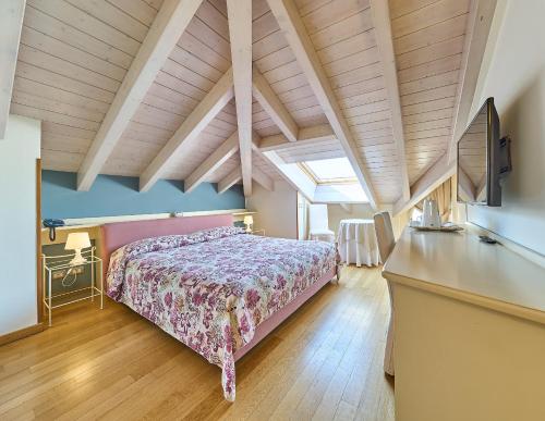 a bedroom with a bed and a desk in a room at Hotel Belvedere Ranco in Ranco