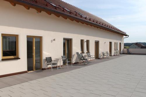 a building with chairs and tables on a patio at Landhotel Winter in Gebenhofen