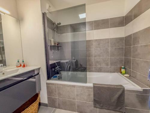 une salle de bain avec une baignoire et un lavabo dans l'établissement T3 dans Résidence avec Piscine , plage à pieds et proche commerces, au Lavandou