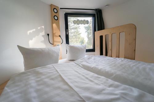 a white bed in a room with a window at slube an den Teichen Hoher Fläming in Rottstock
