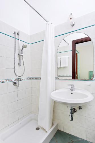 un bagno bianco con lavandino e specchio di Da Giorgio a Capri