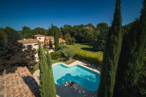 - une vue sur la piscine dans une cour arborée dans l'établissement Magnifique Villa Provençale, à Rognes