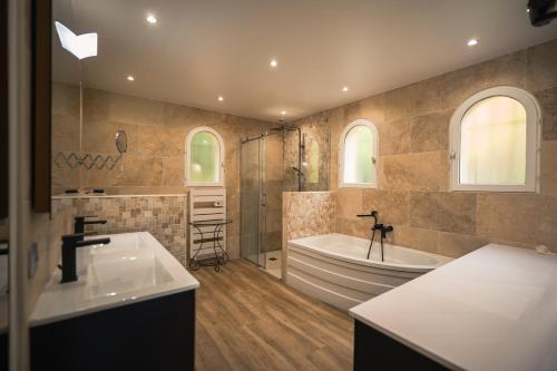 une salle de bain avec une baignoire, une douche et un lavabo dans l'établissement Magnifique Villa Provençale, à Rognes