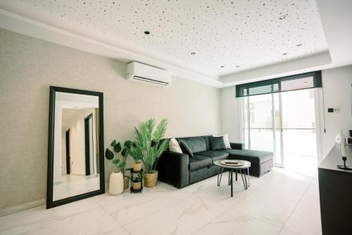 a living room with a couch and a mirror at 2BR Amalfi Blue Apt in Larnaca - Pool & 10Min Walk to Mackenzie Beach! in Larnaca