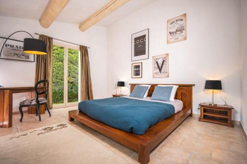 une chambre avec un grand lit avec une couverture bleue dans l'établissement Magnifique Villa Provençale, à Rognes