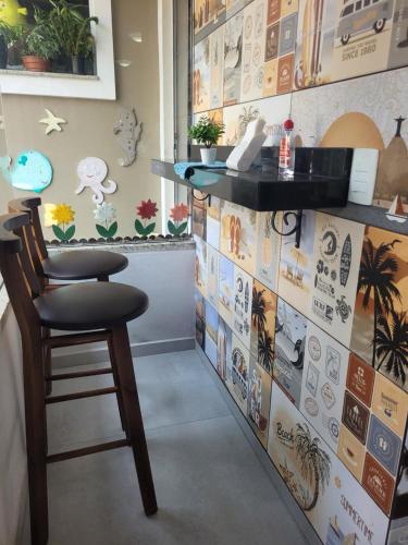 a bar with a chair and a wall with pictures at Pousada Rota dos Mares in Penha