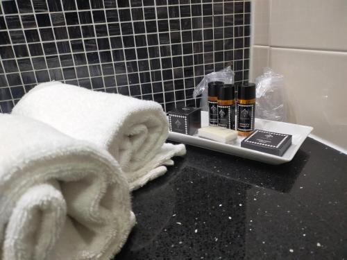 a bathroom with towels and cosmetics on a counter at MICHELINO 75 by the Sydney Hotel in Bologna