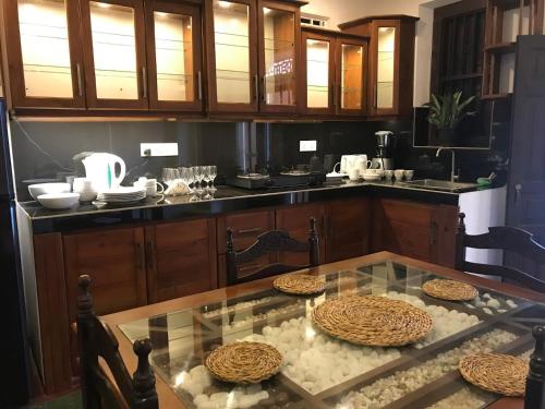a kitchen with a glass table and some chairs at Villa Utopia Mirissa in Mirissa