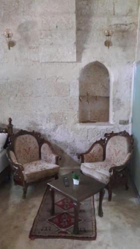 a living room with two chairs and a table at Born Hotel in Urgup