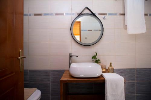 a bathroom with a sink and a mirror on the wall at Lemon House Lefkada in Lefkada