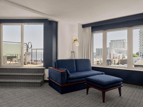a living room with a blue chair and a stool at Courtyard by Marriott Halifax Downtown in Halifax