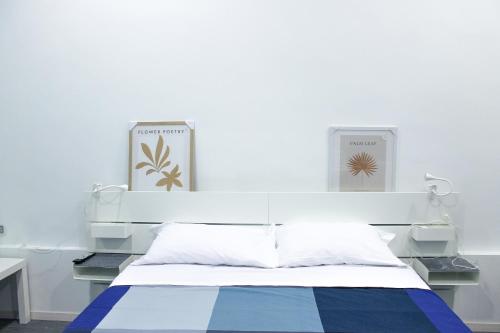 a bed in a room with a white wall at di fronte al museo in Gela