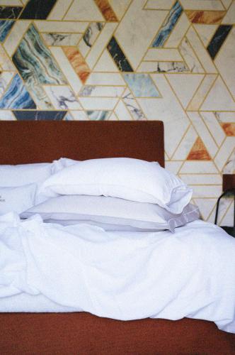 a bed with white sheets and pillows in a bedroom at Casa do Romezal in Peso da Régua