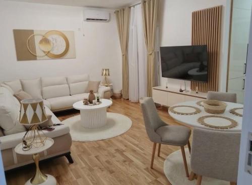 un soggiorno con un divano bianco e una TV di Maja 12 a Podgorica