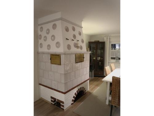 a brick fireplace in a living room with a table at Ferienwohnung im Haus Schwedes in Titisee-Neustadt