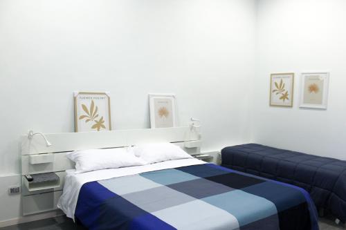 a bedroom with a bed with a blue and white blanket at di fronte al museo in Gela
