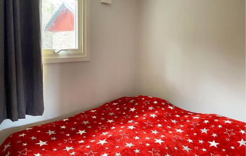 a red blanket with white stars on a window at Nice Home In Borgholm With Sauna in Borgholm