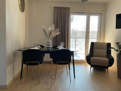 a dining room with a black table and chairs at Apartament ELEGANCE in Zamość