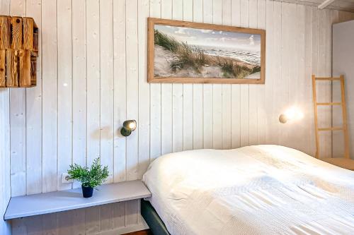 a bedroom with a bed and a picture of a beach at Strandblick - Dorf 1 Ferienhaus 16 in Priwall