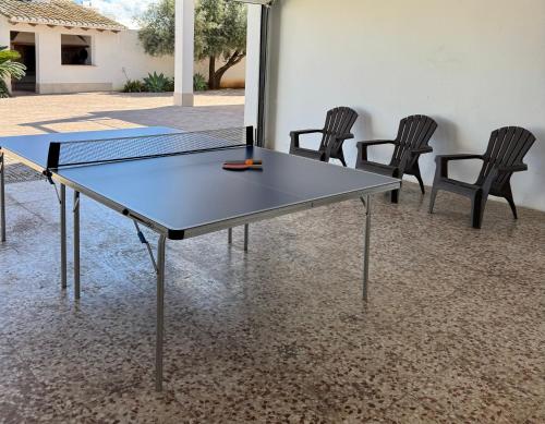 a ping pong table with four chairs around it at Villa Conchin Casa junto a Parque Natural in Alberique