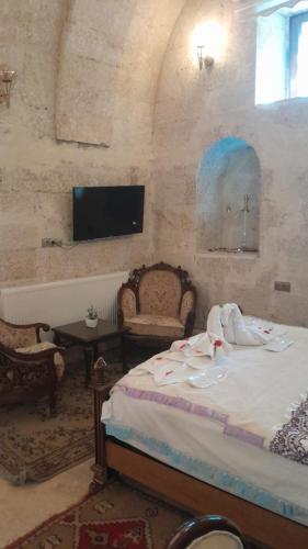 a bedroom with a bed and a tv on the wall at Born Hotel in Urgup