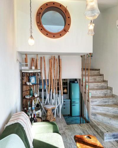 a living room with a green couch and a mirror at Aelia House Chalkidiki in Fourka