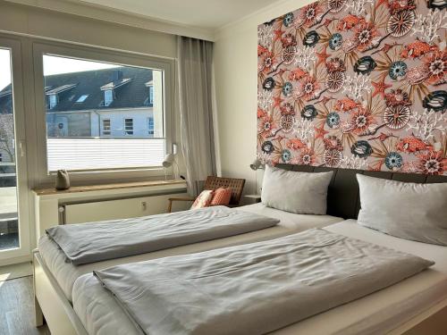 a bedroom with two beds and a window at Dünenrose Seegras Nr 41 in Norderney