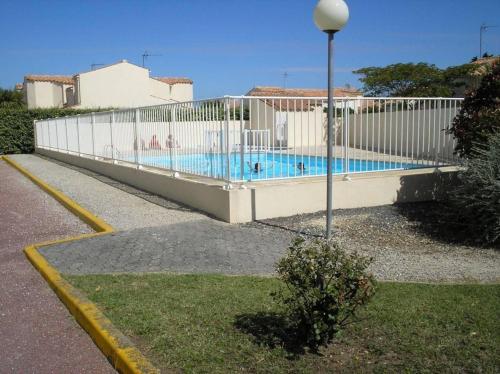 une clôture blanche à côté d'une piscine dans l'établissement Mais 4 pièces Oléron 6 couchages - SAINT-DENIS D'OLERON SDO000-013, à Saint-Denis-dʼOléron