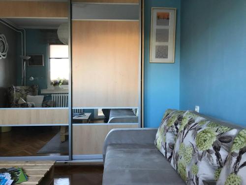 a living room with a couch and a glass wall at Recently renovated room with Danube view in Novi Sad