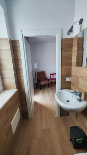 a bathroom with a sink and a room with a chair at Pozzilli Affitacamere Appartamenti in Pozzilli