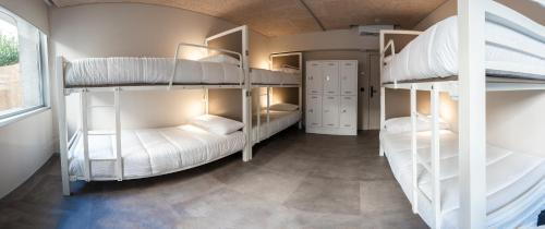 a room with three bunk beds in it at Lamia BBK Women Hostel-Solo mujeres in Bilbao