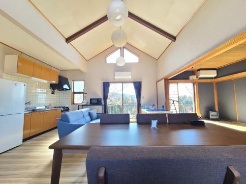a kitchen and living room with a wooden table and a dining room at 富士山を背景に豊かな自然やバーベキューが魅力のコテージ Sakura in Kannami