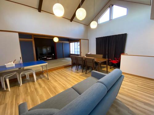 a living room with a couch and a table at 富士山を背景に豊かな自然やバーベキューが魅力のコテージ Sakura in Kannami