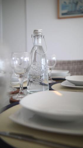 a table with plates and glasses and a bottle of water at Condominio Náutico SOTAVENTO - PARACAS in Paracas