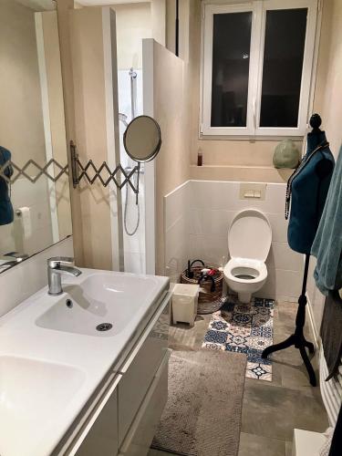 une salle de bain avec un lavabo blanc et des toilettes dans l'établissement Villa Baliste et sa piscine aux Sables d'Olonne, à Château-dʼOlonne