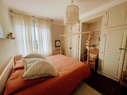 - une chambre avec un lit orange et 2 oreillers dans l'établissement Villa Baliste et sa piscine aux Sables d'Olonne, à Château-dʼOlonne