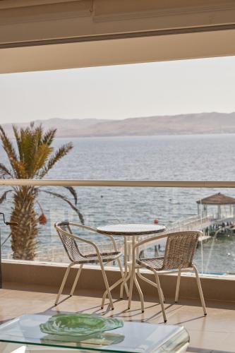 a table and chairs on a balcony with a view of the water at Condominio Náutico SOTAVENTO - PARACAS in Paracas
