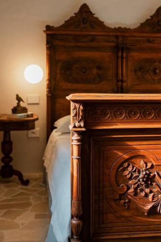 a bedroom with a large wooden bed with a fireplace at L'edicola di Ripalvella in San Venanzo