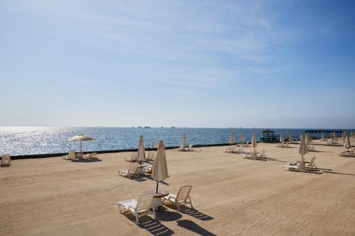 a group of chairs and umbrellas on a beach at Condominio Náutico SOTAVENTO - PARACAS in Paracas