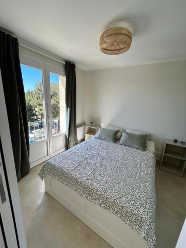 une chambre avec un lit et une grande fenêtre dans l'établissement Le Cocon des Floréal, à Bandol