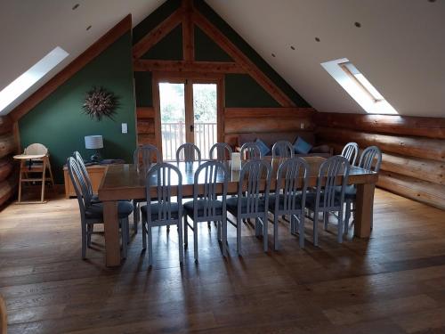 a dining room with a wooden table and chairs at Fir Lodge in Kings Lynn