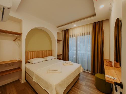a bedroom with a large bed and a large window at Marla Suite Fethiye in Fethiye