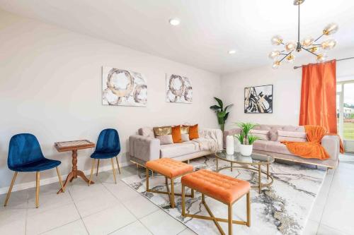 Designer Decorated - 3 Bedroom NEAR DISNEY في كيسيمي: غرفة معيشة مع أريكة وكراسي زرقاء